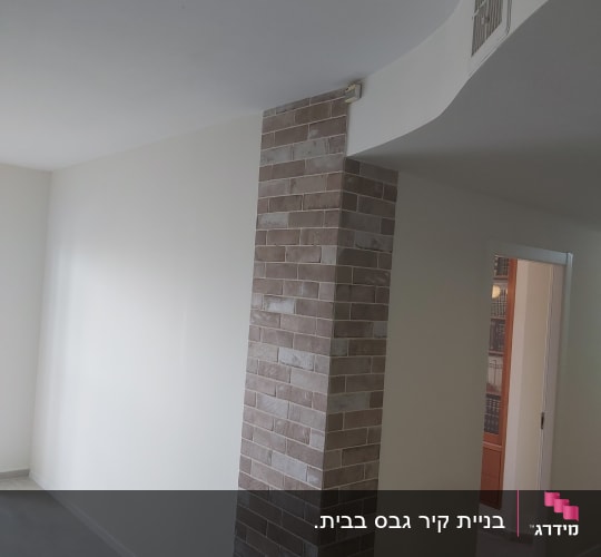 קיר גבס צבוע בלבן עם עמוד לבנים